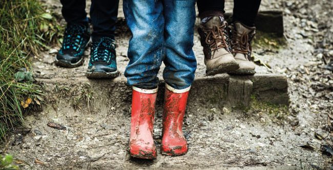 A child's feet wearing red wellies