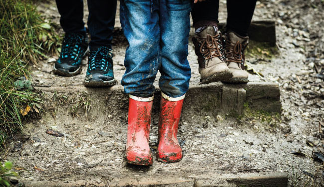 A child's feet wearing red wellies